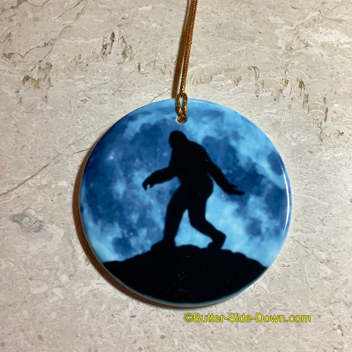 Bigfoot walking across a blue full moon ceramic ornament